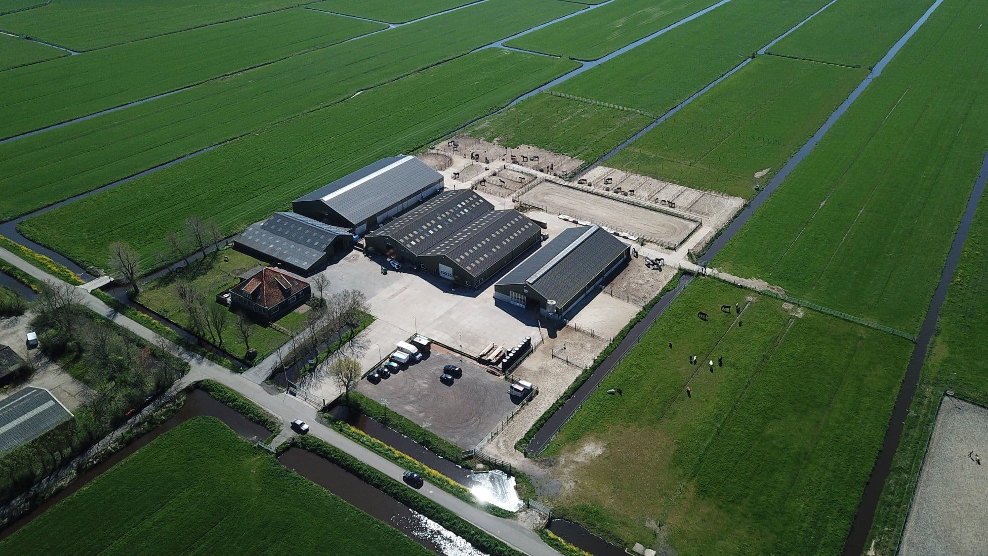 Luchtfoto van het terrein van Melman BV tussen de weilanden